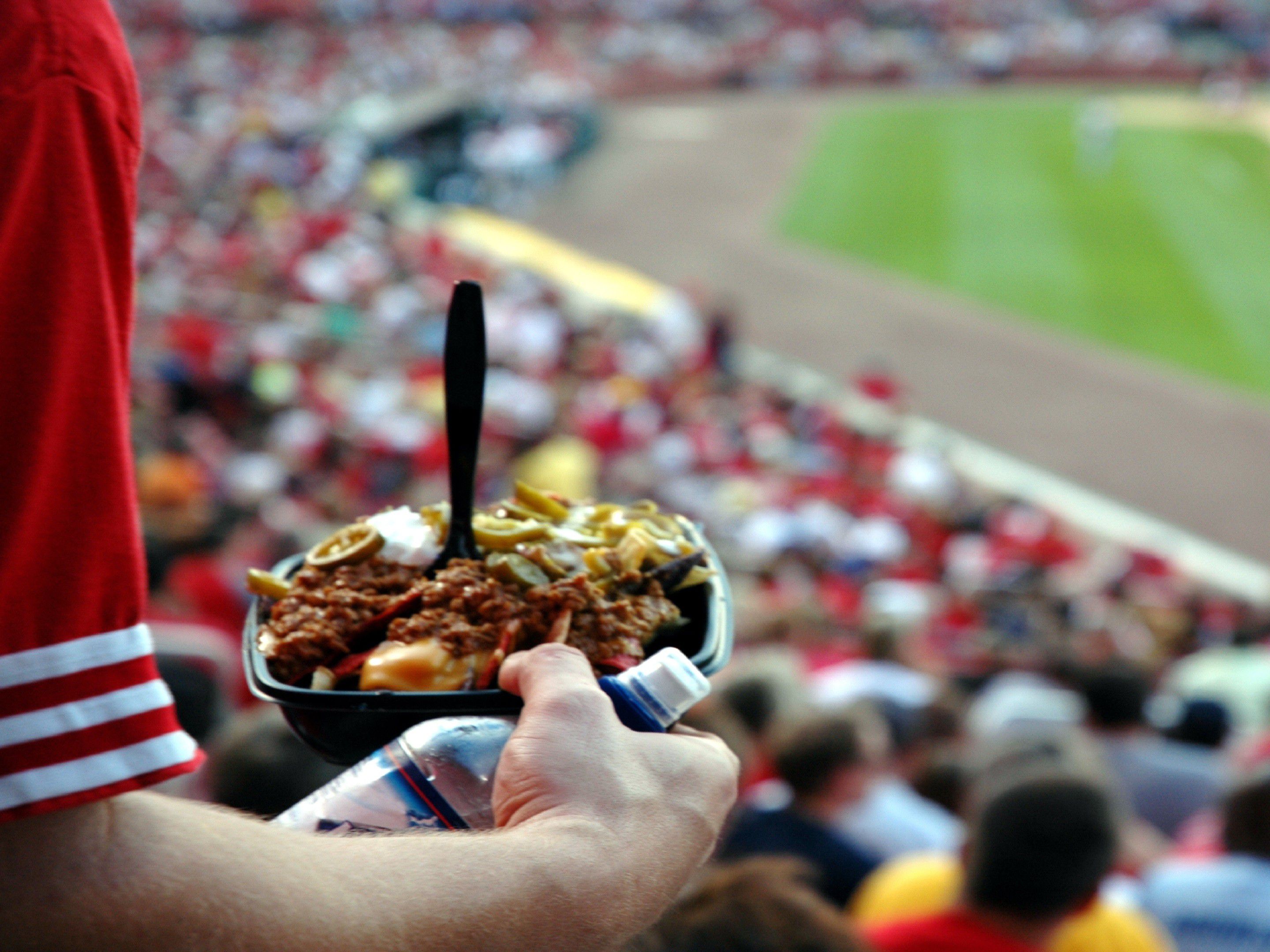 baseball fan holding food in stands