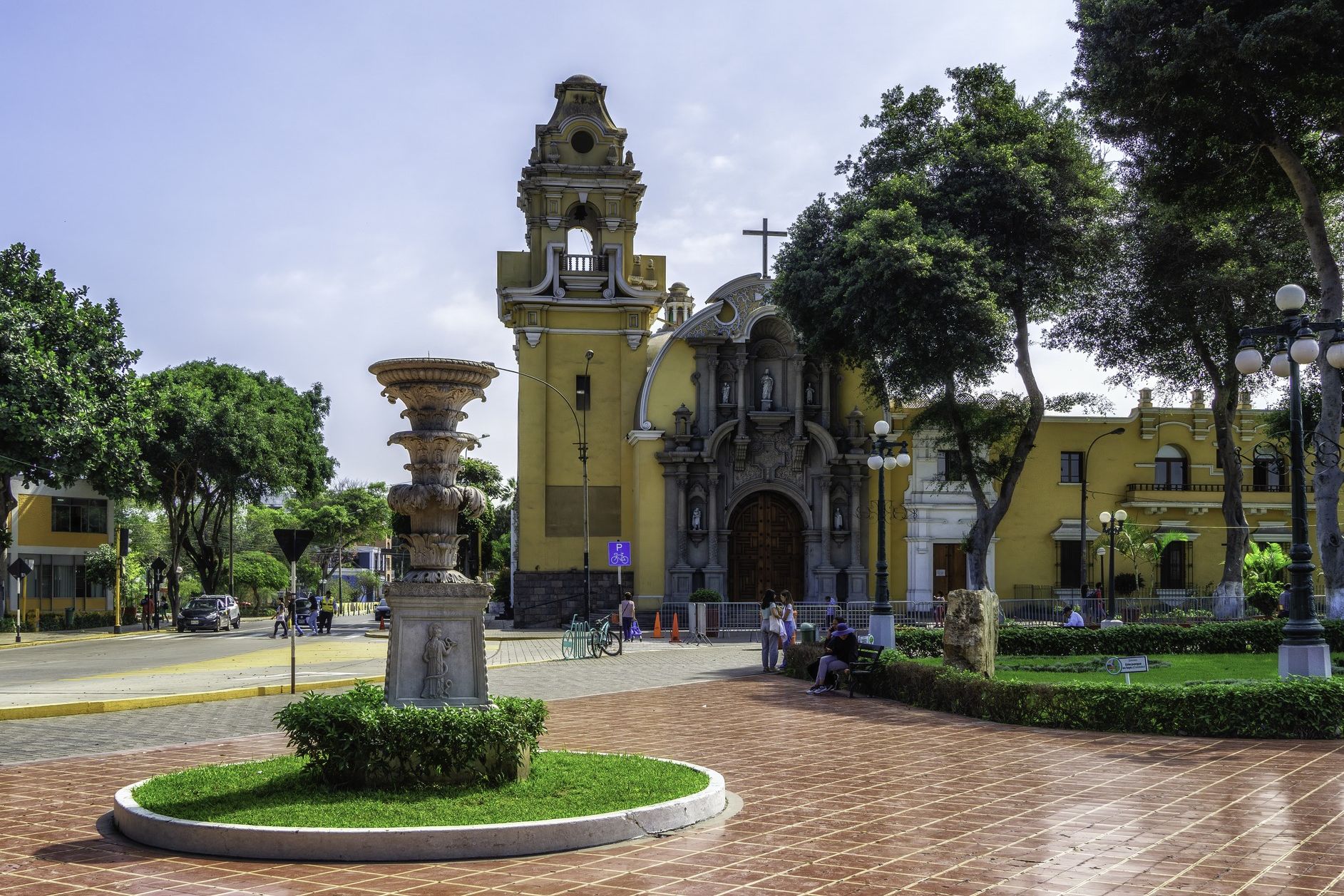 Historic church and plaza in Lima's Barranco district, surrounded by trees and gardens.