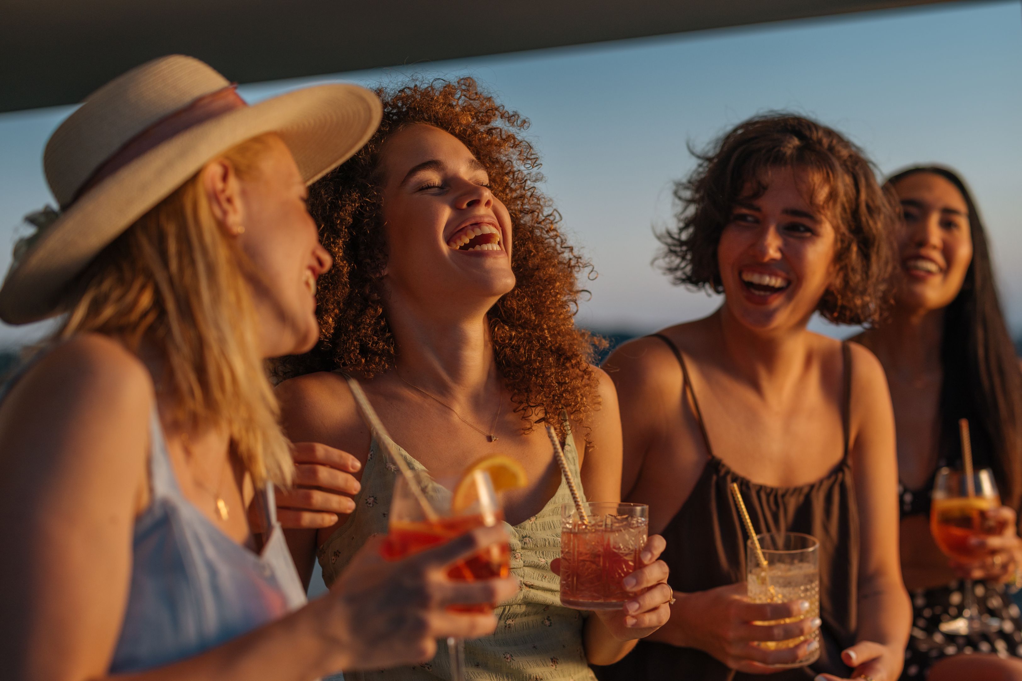 Friends enjoying cocktails during sunset.