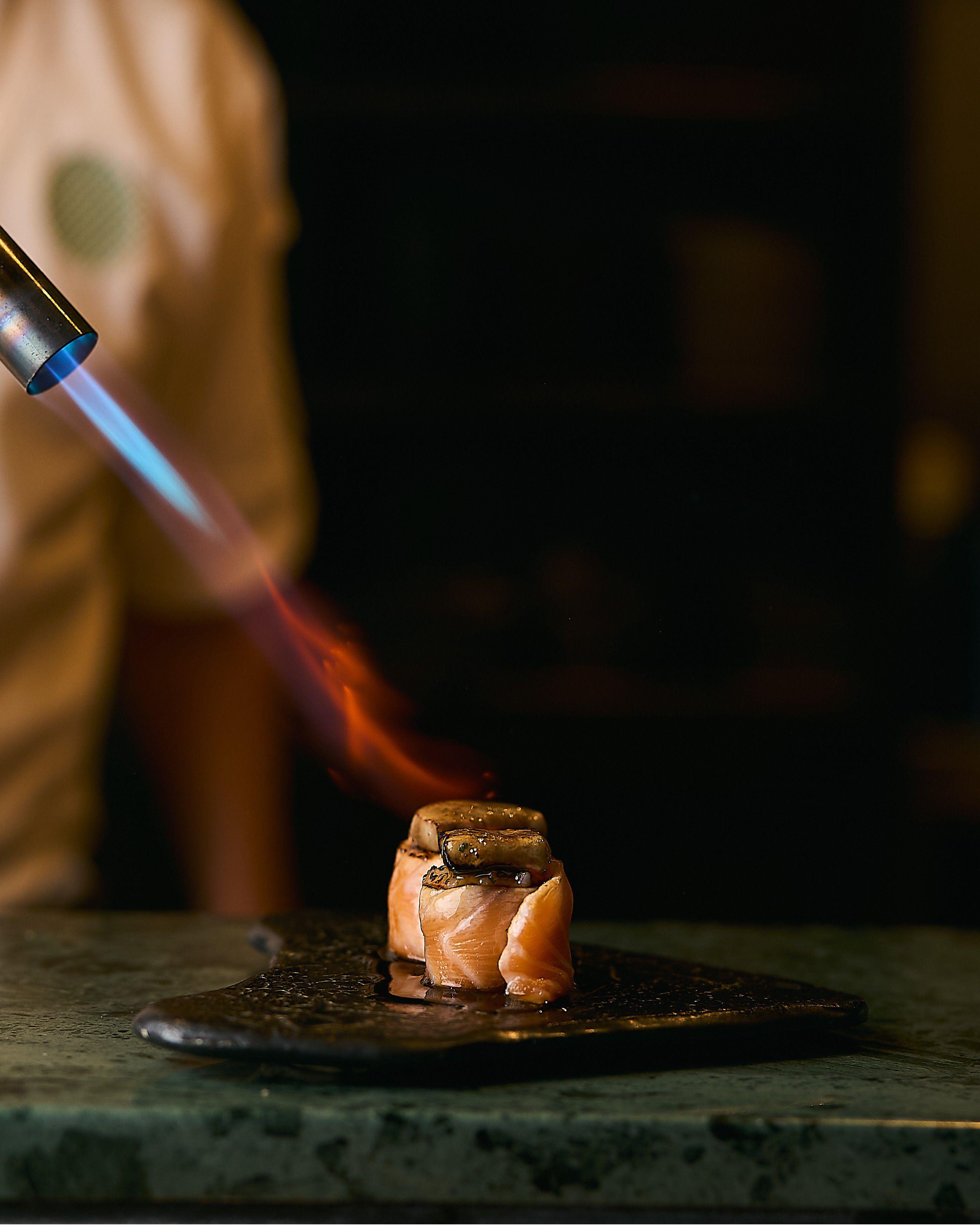 Chef using a blowtorch on sushi