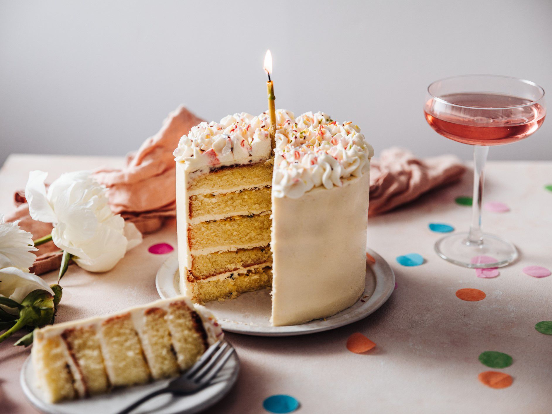 Sliced birthday cake with a single candle