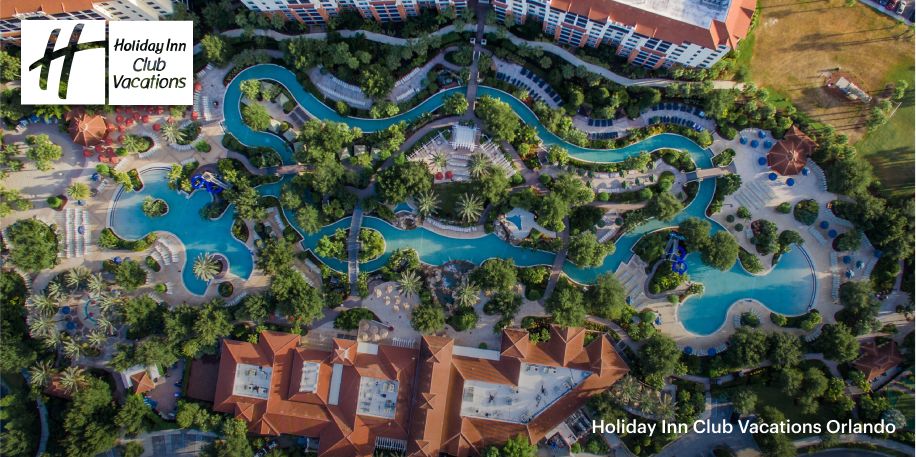  Vue aérienne du Holiday Inn Club Vacations de l'Orange Lake Resort, avec une rivière tranquille en son centre.