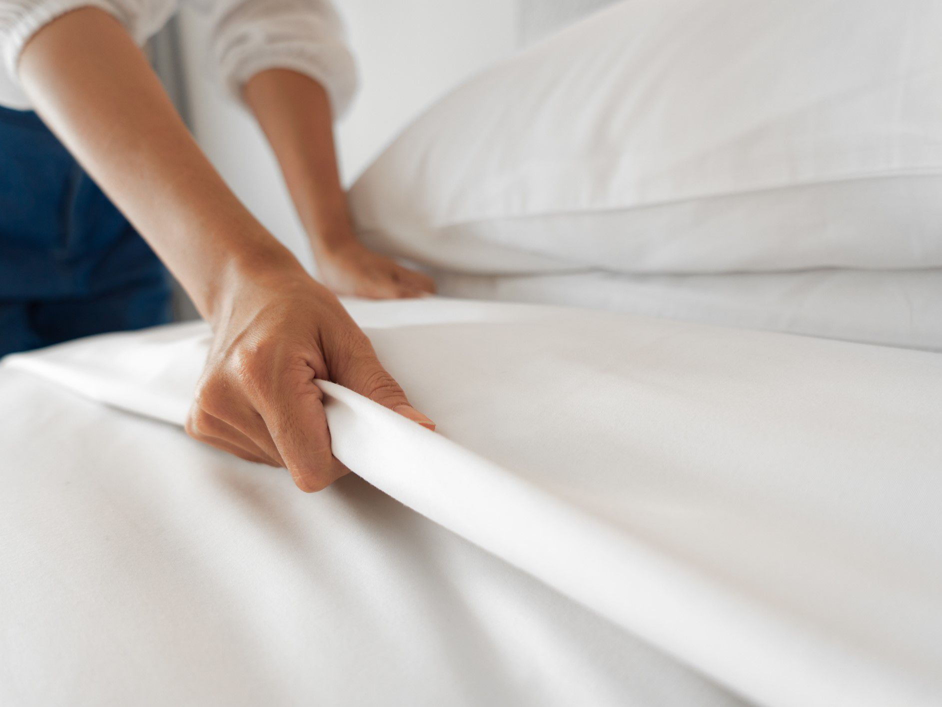 Hotel employee making the bed