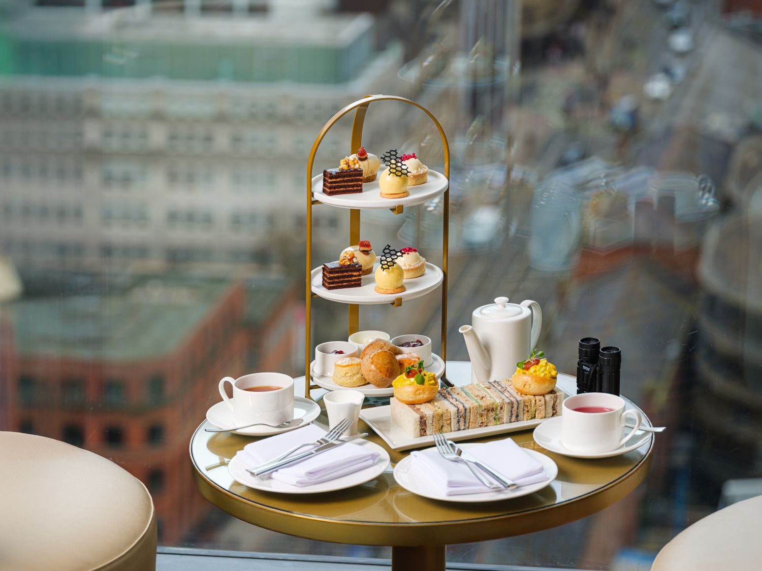Afternoon tea tower with sandwiches and sweet treats and cocktails