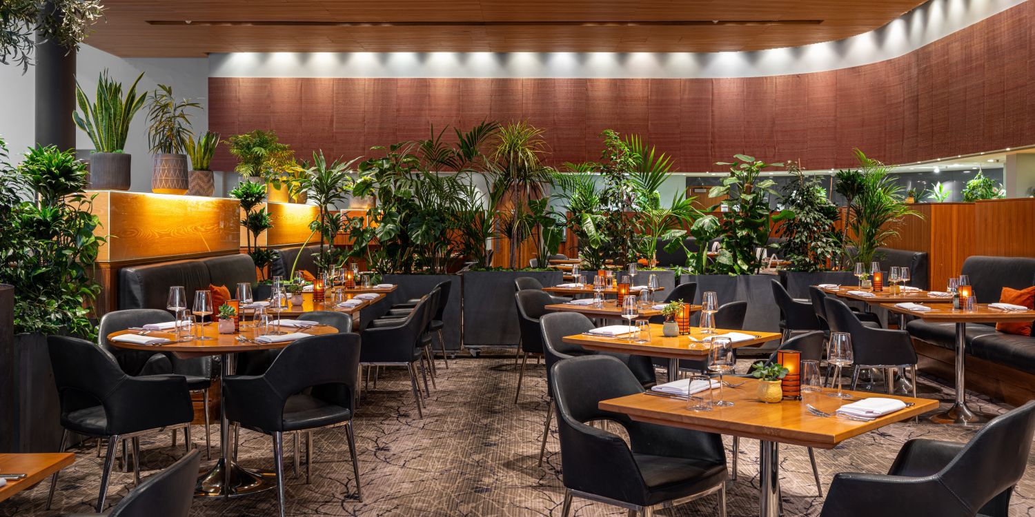 large dining area with plenty tables and plants