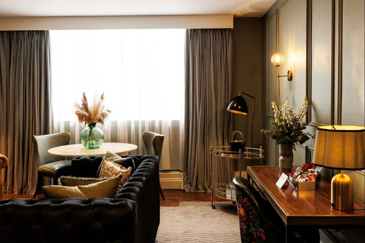 Deluxe king suite with sofa and large window offering natural lighting