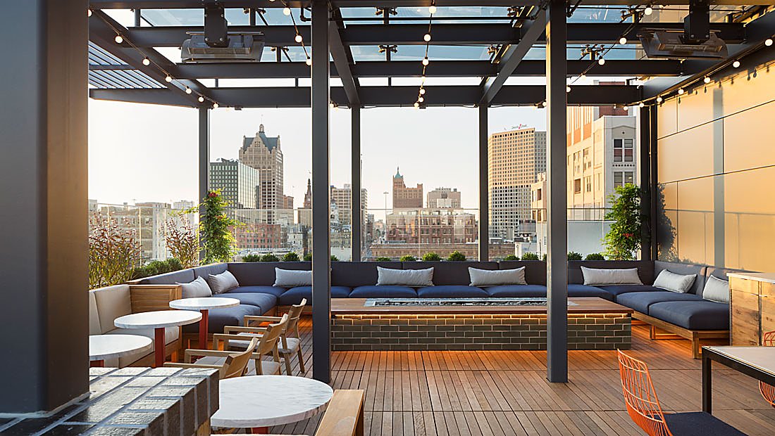 Wooden and iron balcony with Large Couch Seating, long brick fire pit and city view