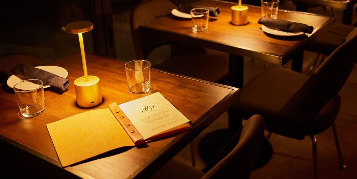 Dining room table with menu for two guests at Aliya 