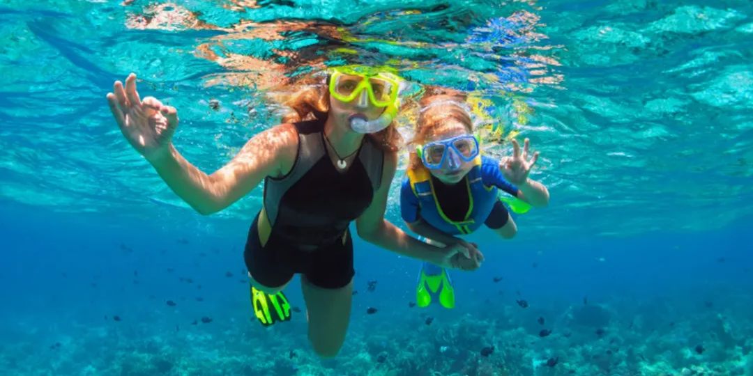 Kids snorkeling in the ocean.