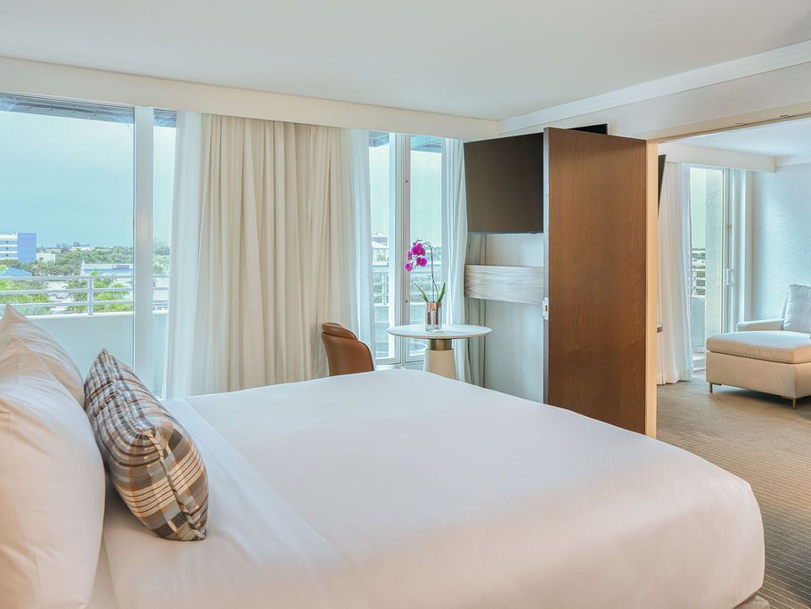 Bright junior suite with a king bed, separate sitting area, floor-to-ceiling windows, and contemporary décor at InterContinental at Doral Miami.