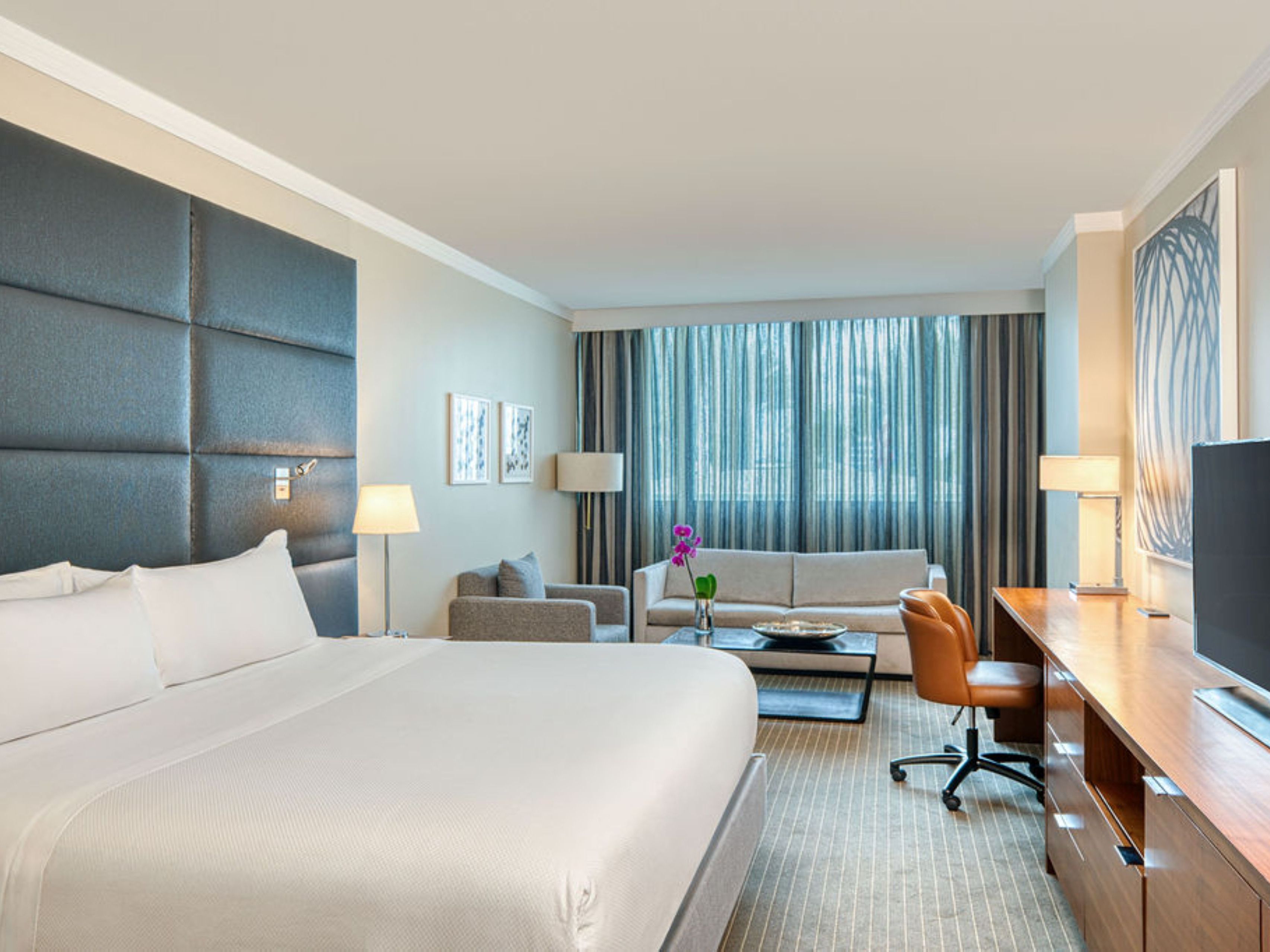Spacious premium guest room featuring a king bed, work desk, seating area with sofa, and contemporary furnishings at InterContinental at Doral Miami.