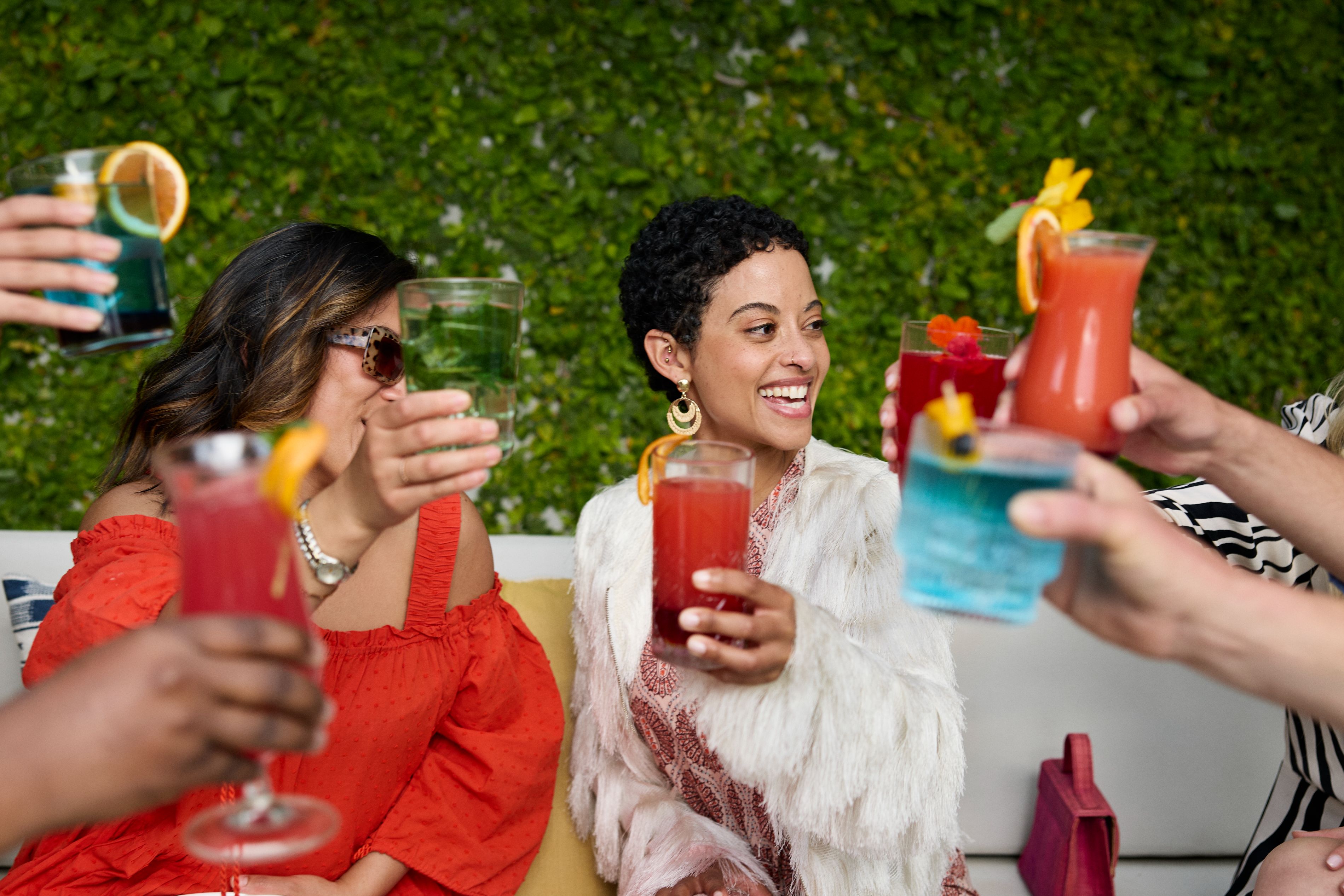 Friends enjoying cocktails at private garden event.