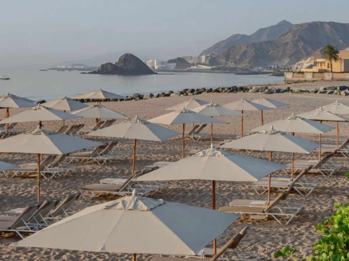 Beach umbrellas and loungers overlooking mountains.