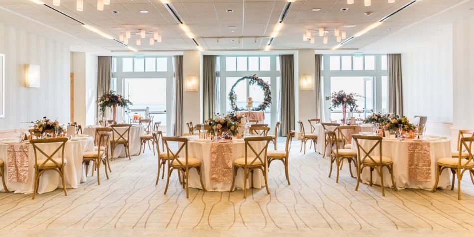Indoor wedding reception set up with round tables and floral decor.