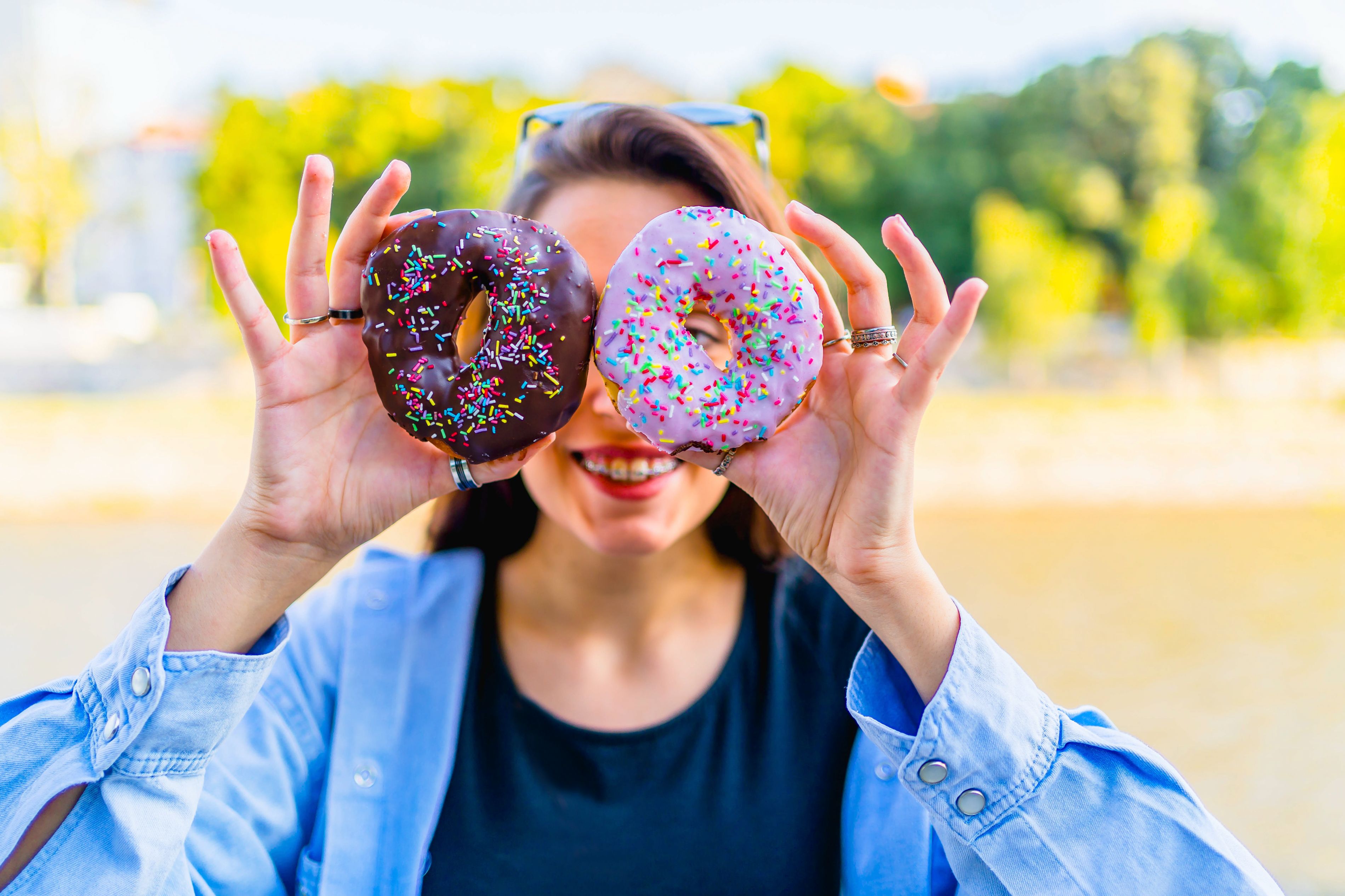 woman holding donuts in front of her face