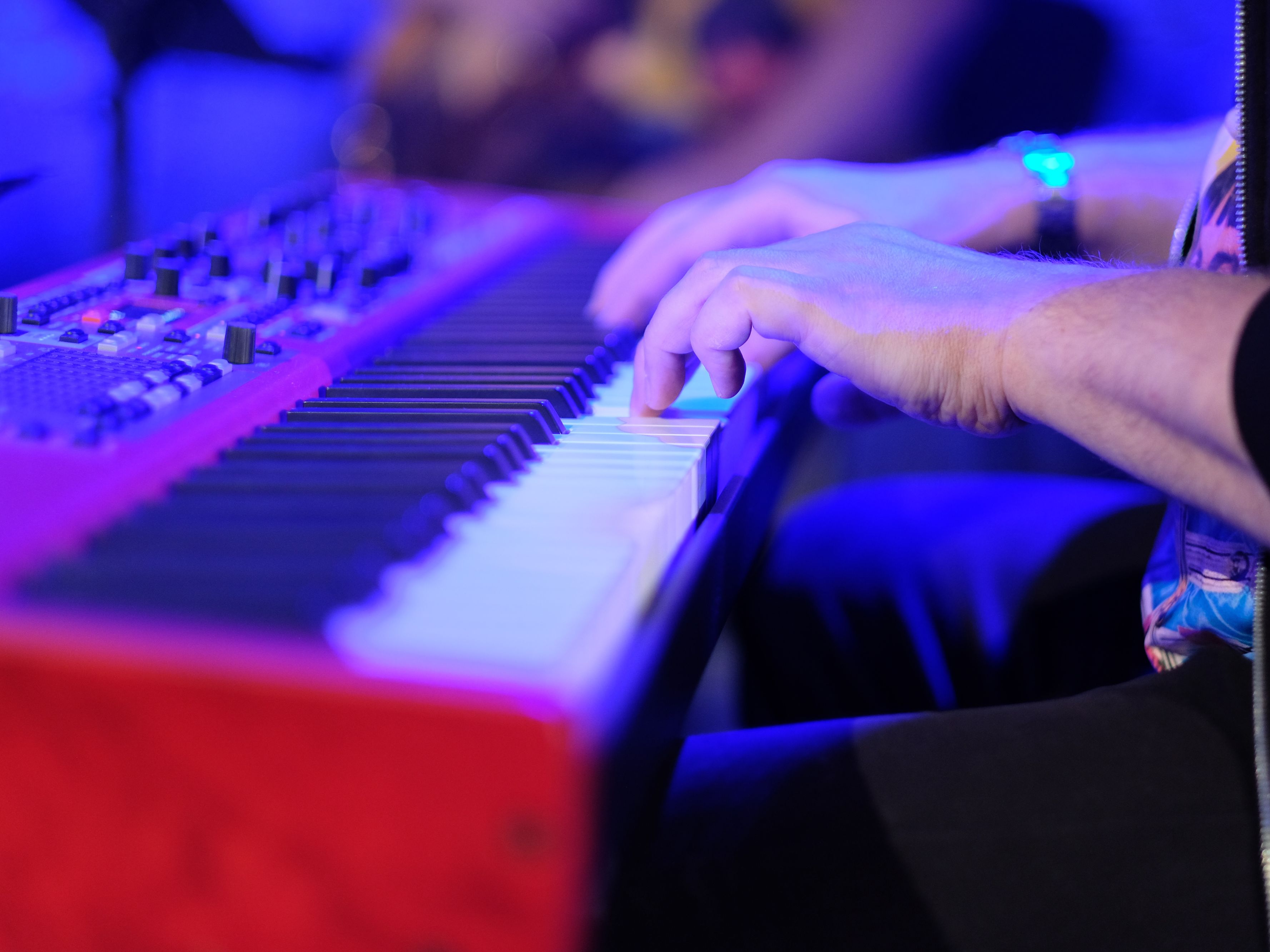 Musician playing an electric piano keyboard.