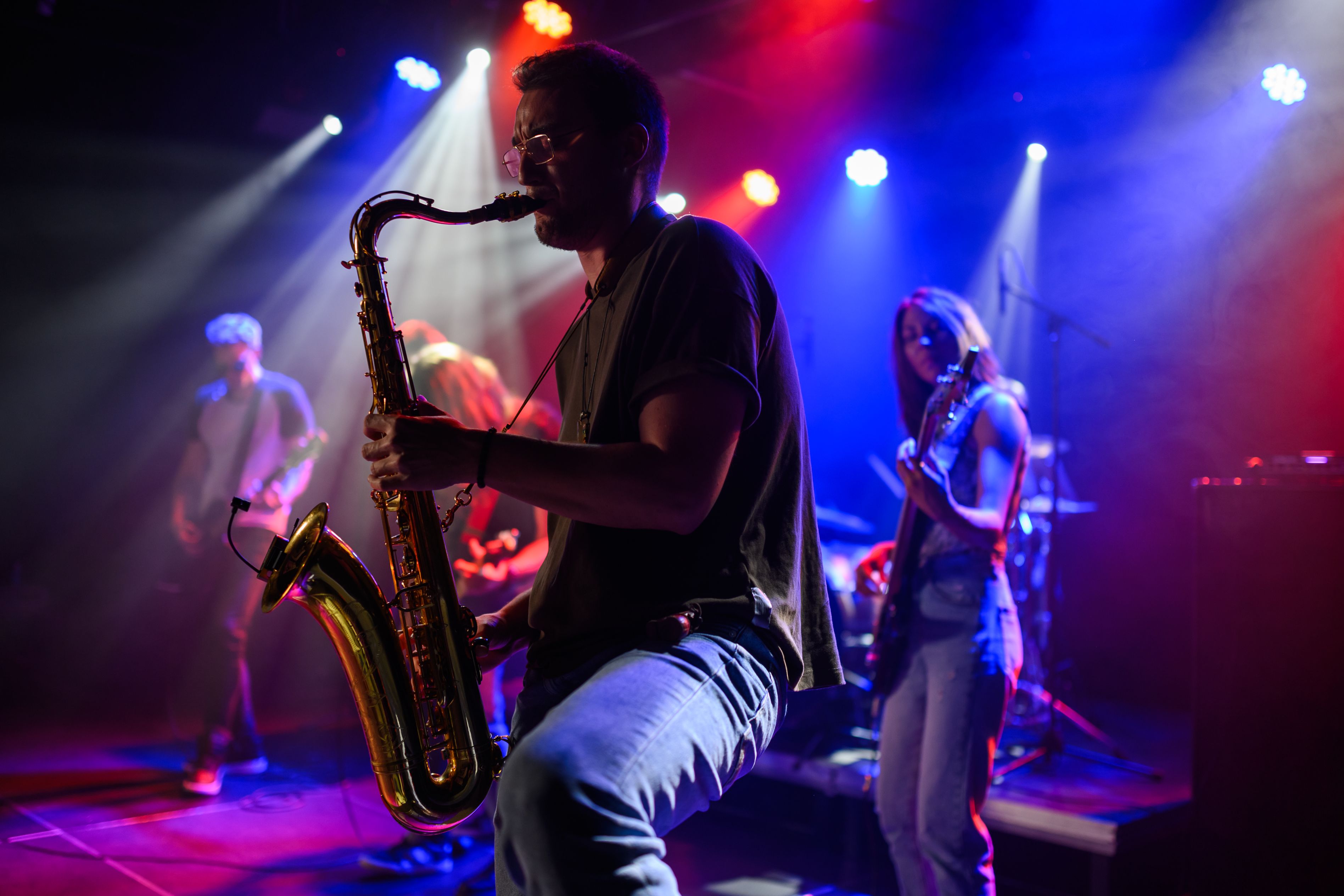 Musician playing saxaphone on stage.