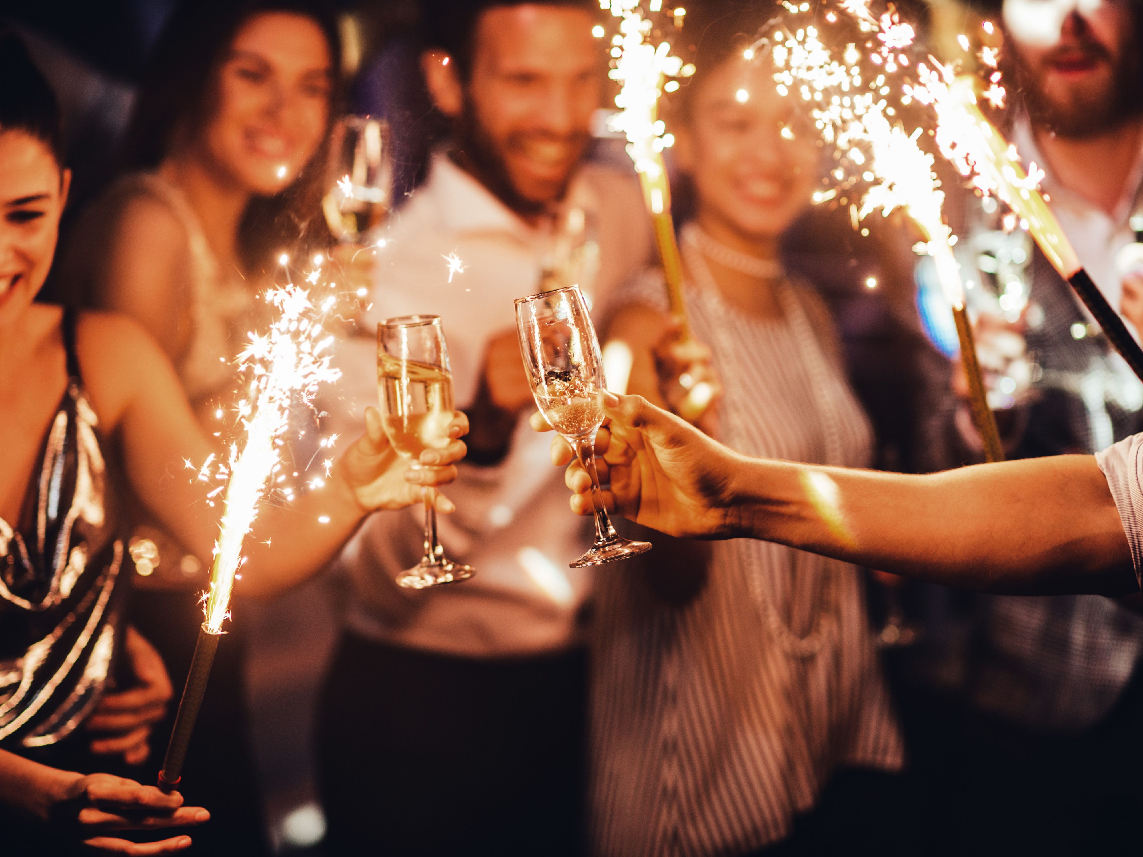Friends with sparklers and champagne glasses celebrating the New Year