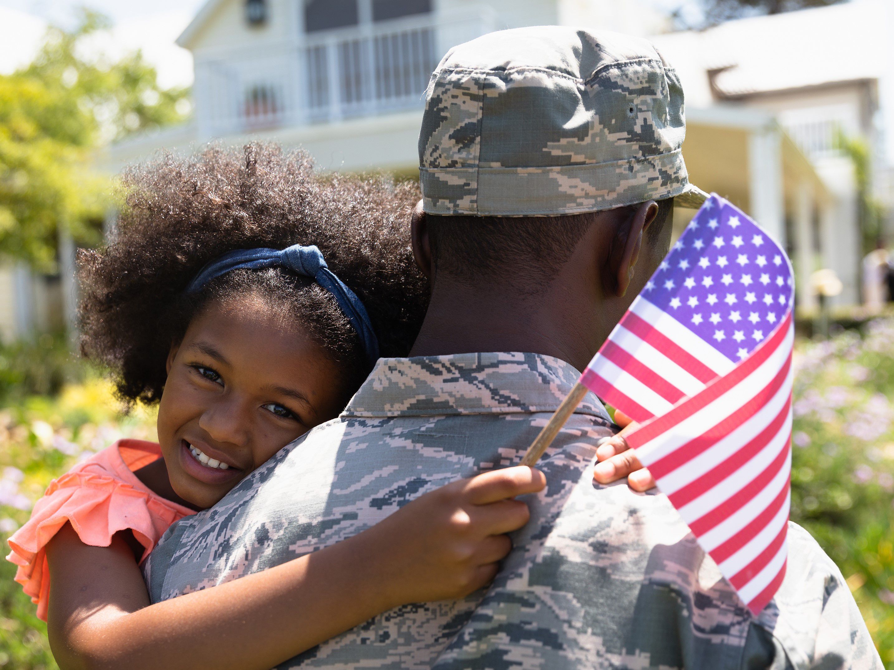 Daughter hugging her military father in uniform