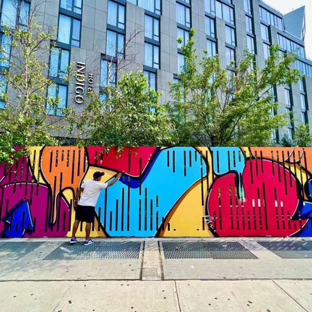 Man standing in front of colorful mural