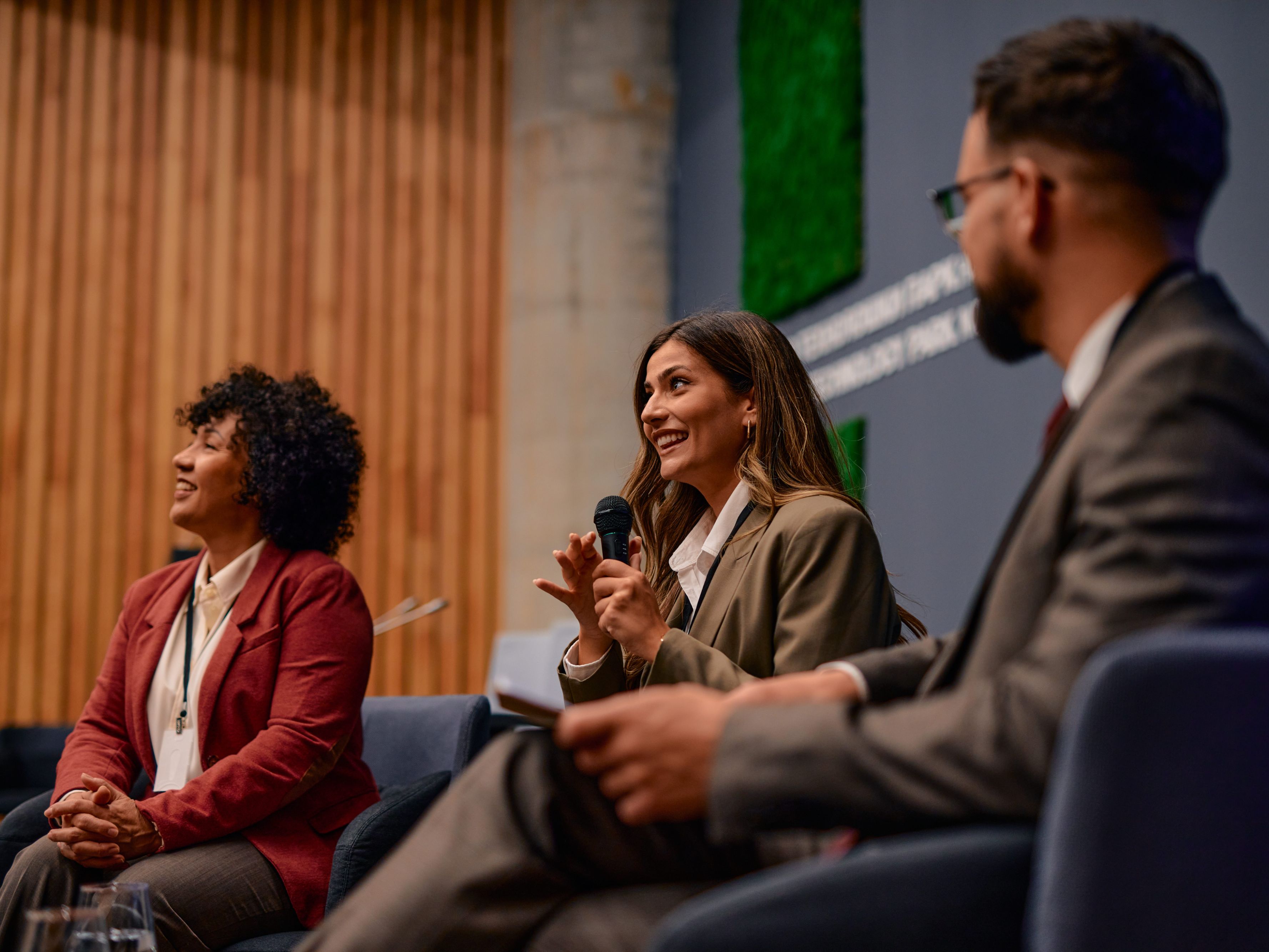People on a panel speaking into a mic