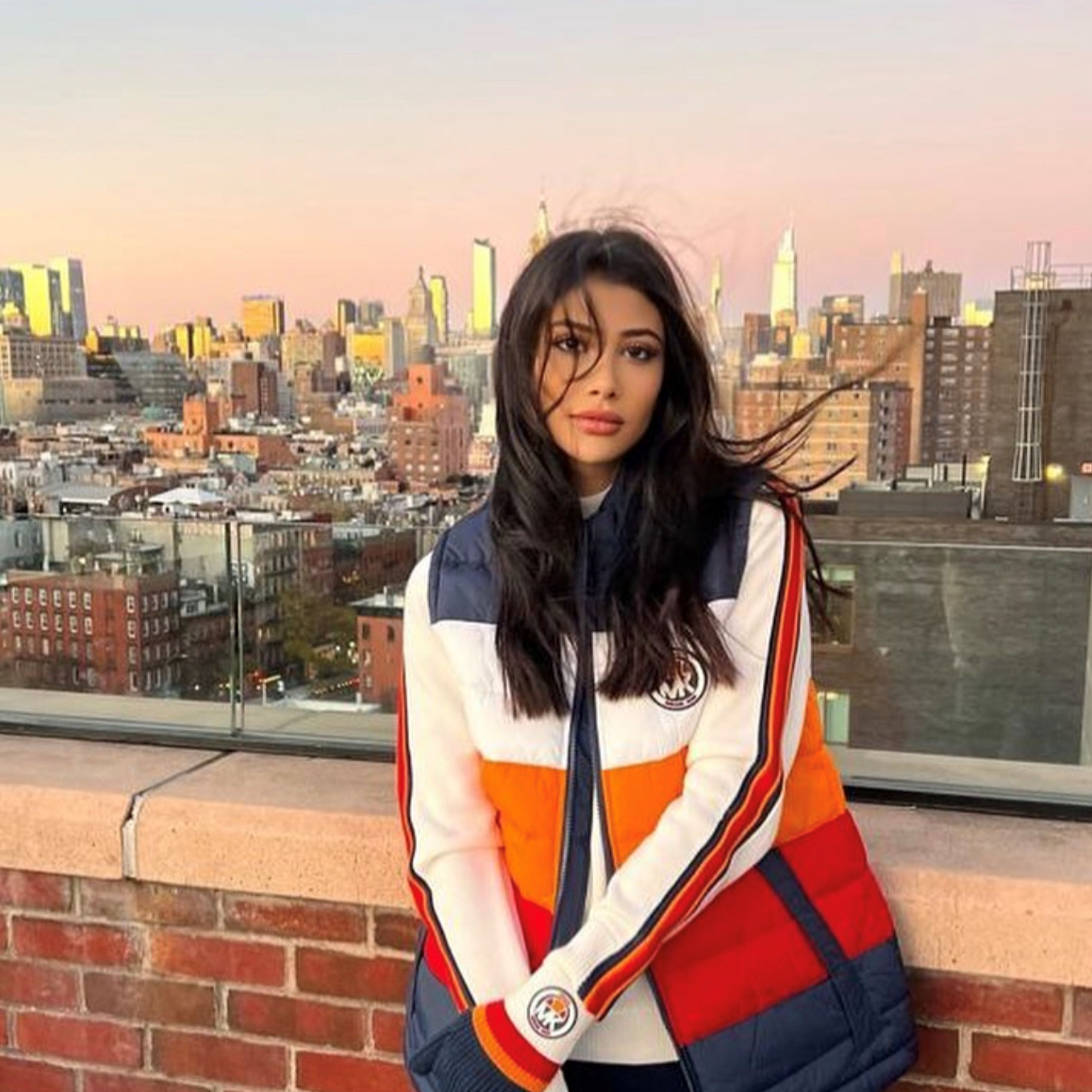 Woman smiling on rooftop with New York skyline 