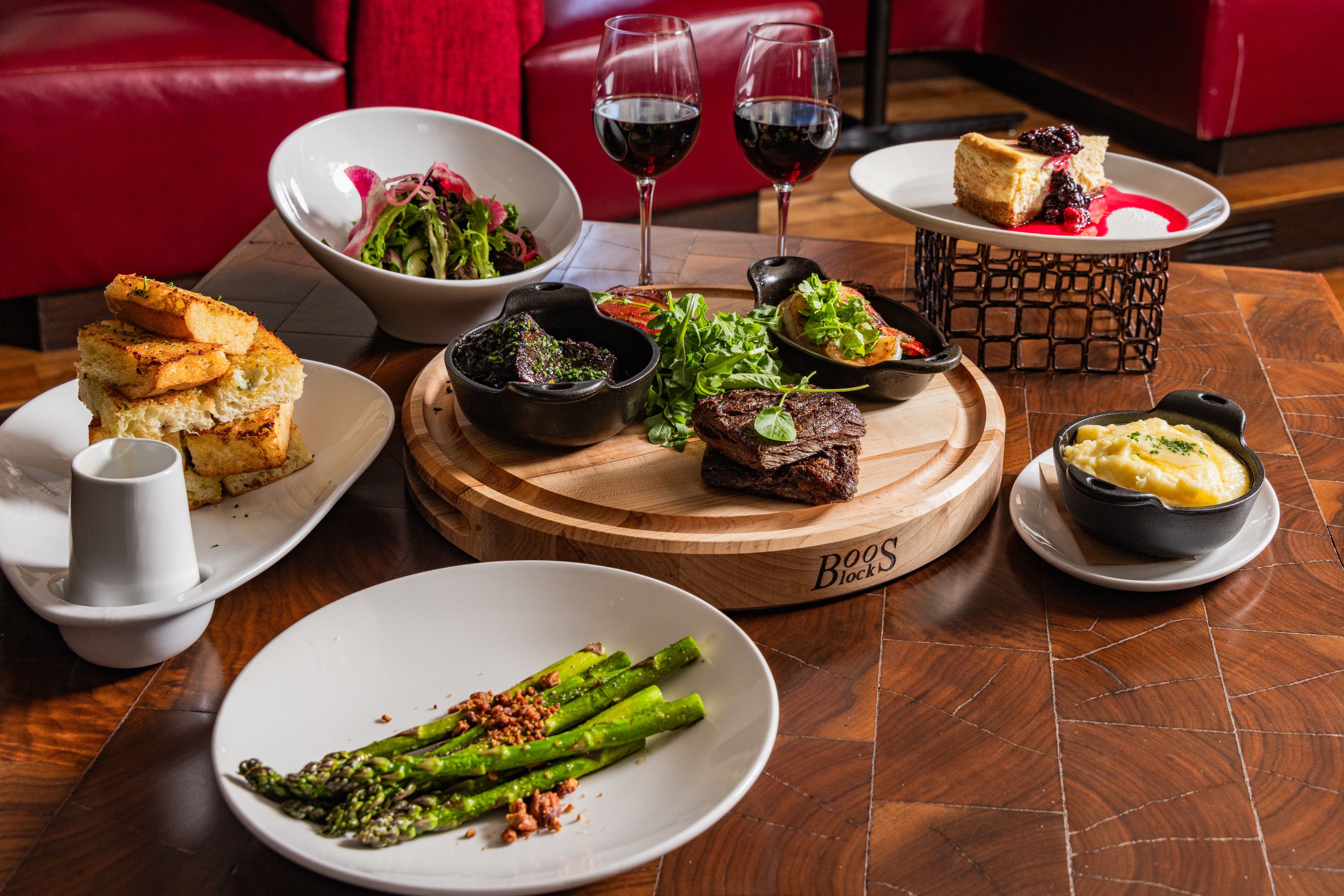 Steak dinner with sides, salad, dessert, and red wine