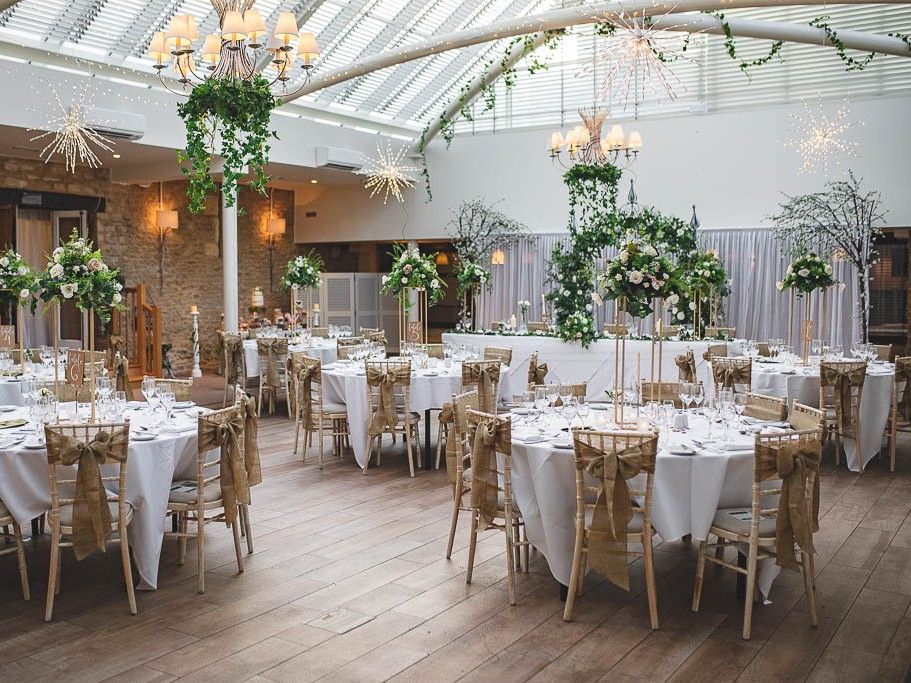 A beautifully decorated sonservatory featuring table and chairs and flowers
