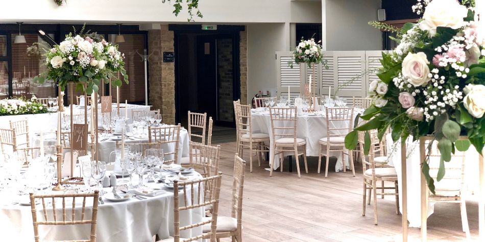 wedding dining area with plenty of tables and chairs in a naturally light room