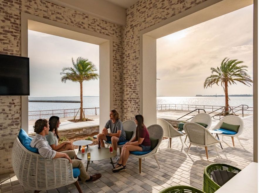 Four people sitting on a covered porch 