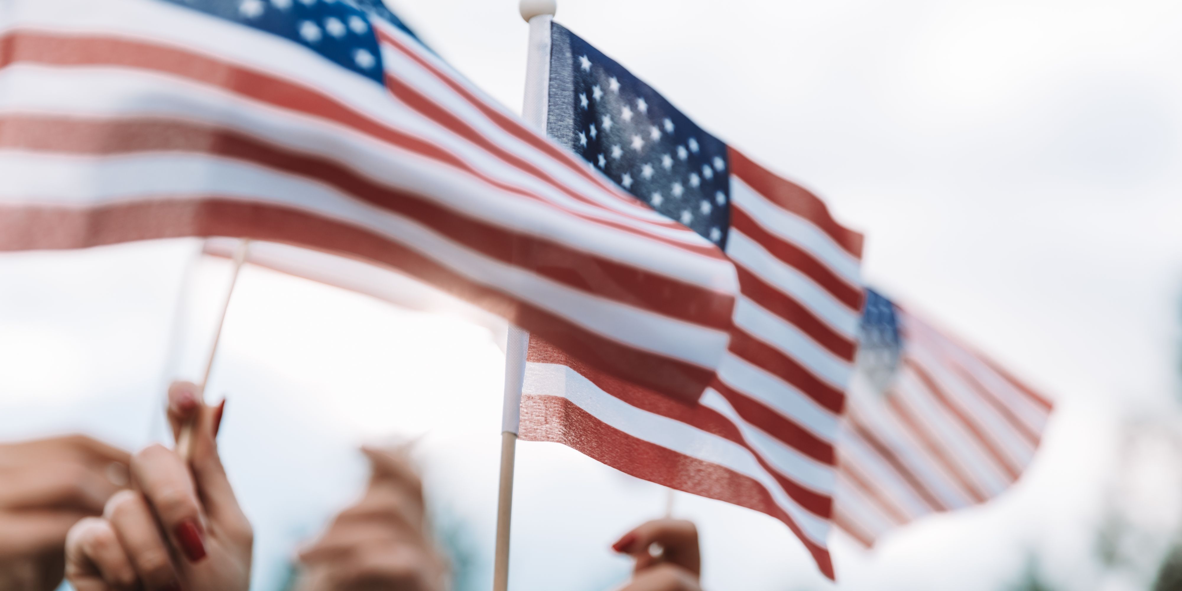 Close up of small American flags being waved by citizens.