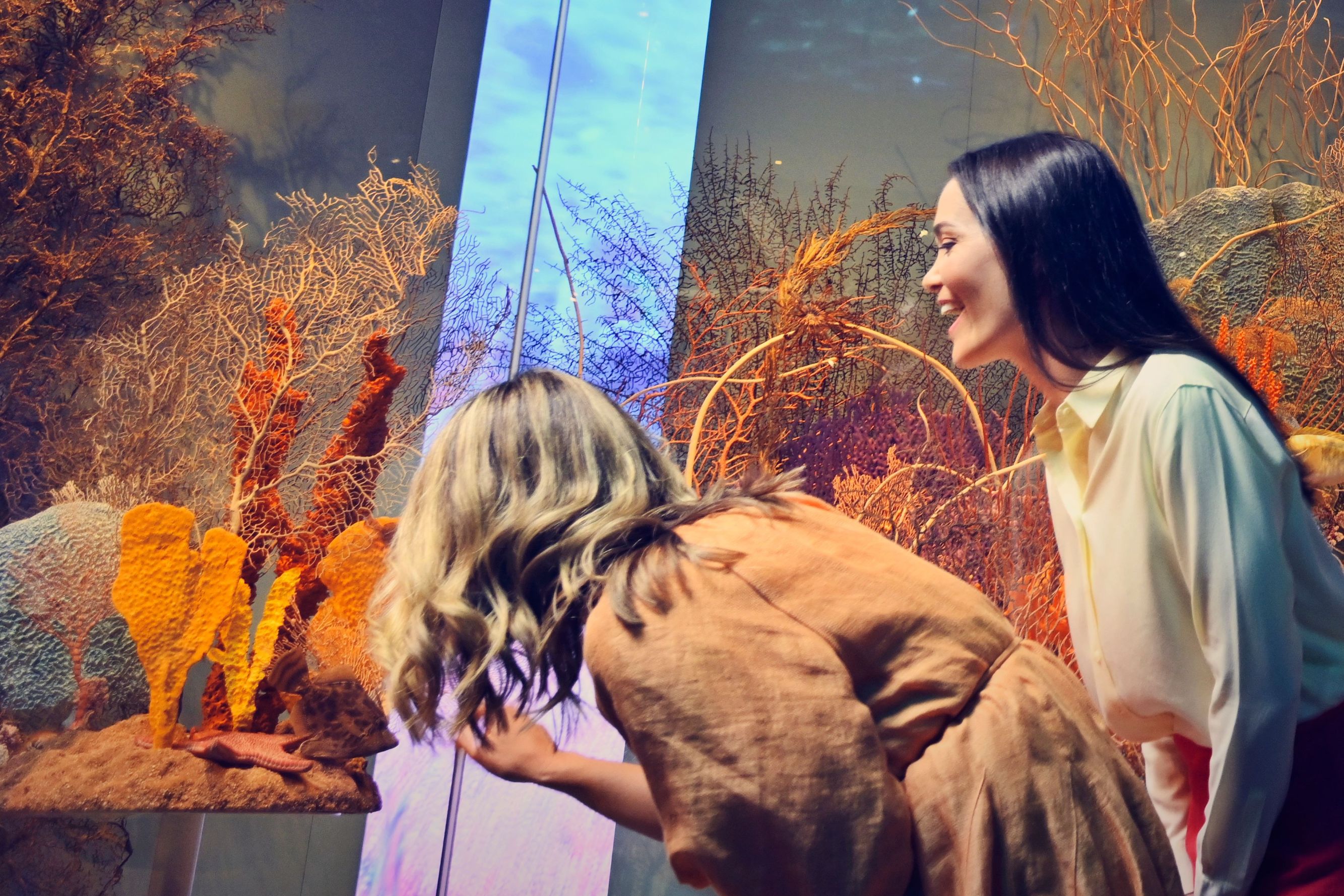 Two women looking at an exhibit at the aquarium. 