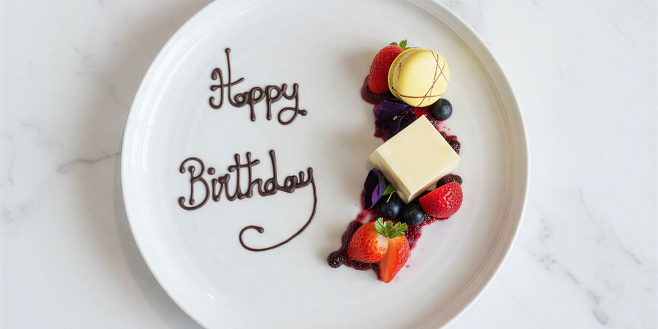 Birthday cheesecake with 'Happy Birthday' written in chocolate.