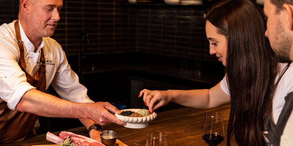 Chef showing guests different seasonings and herbs in a cooking class.