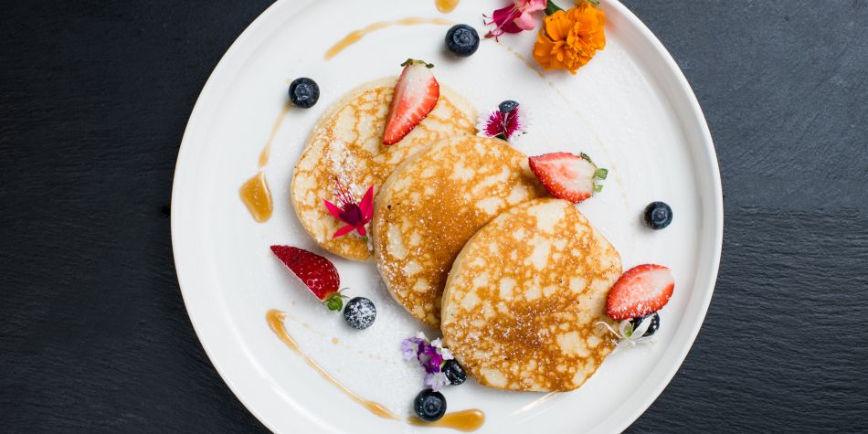 Pancake dish garnished with fruit.