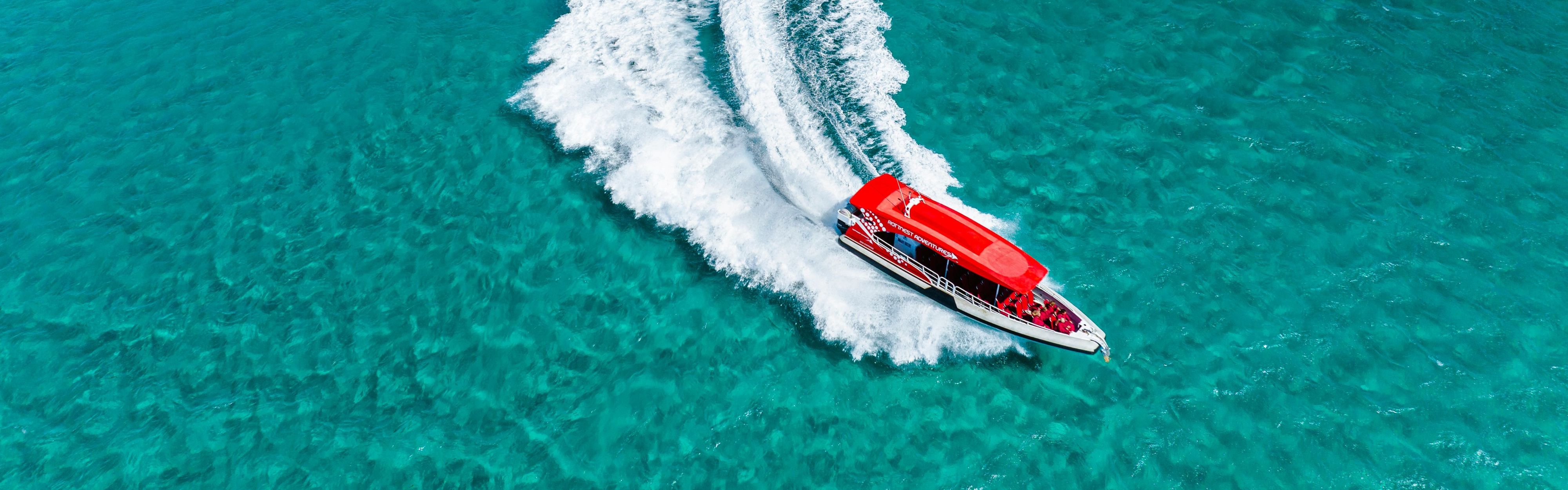 Red boat driving through the water at Rottnest Island.