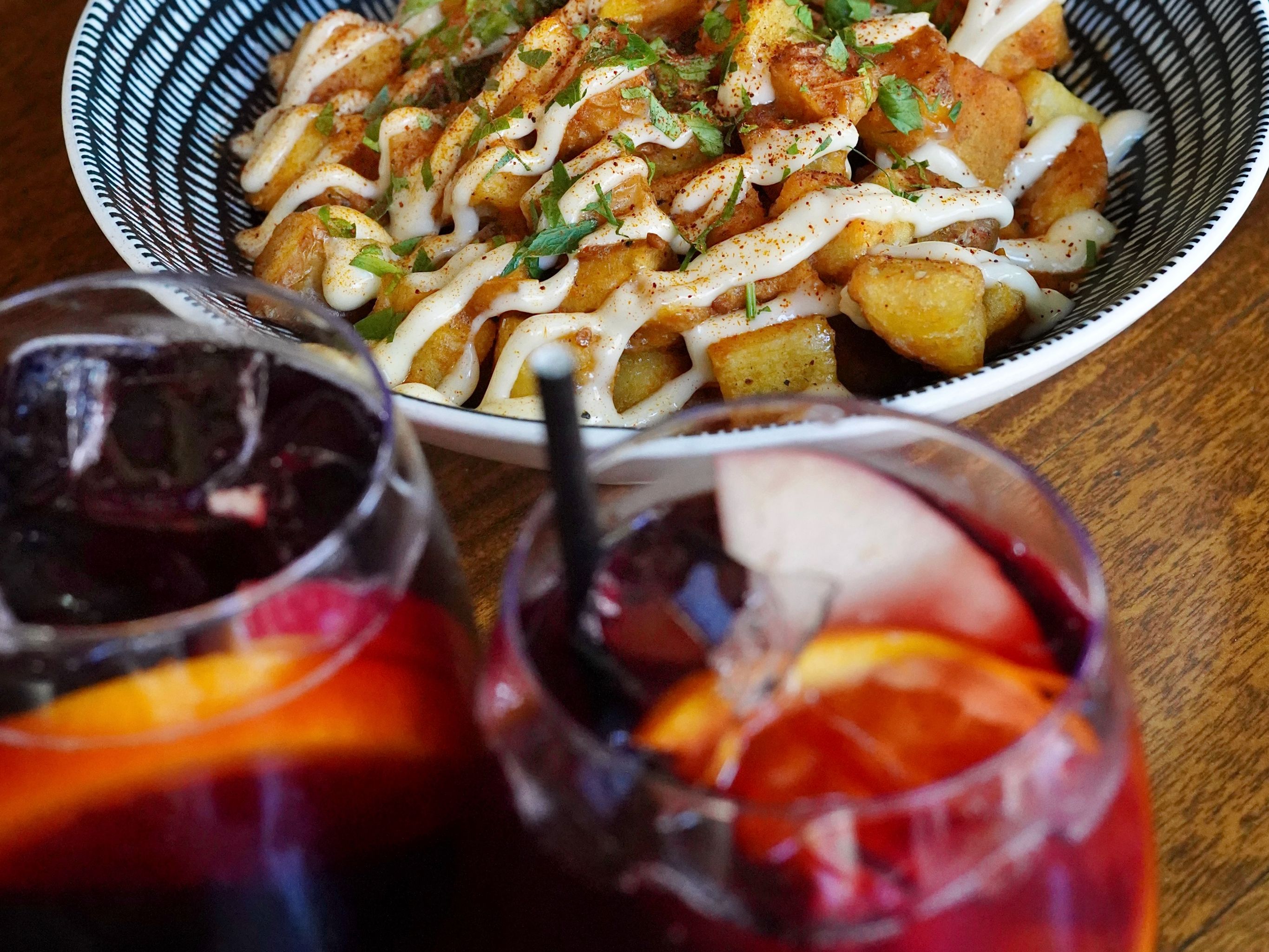 glasses of sangria next to food on a table