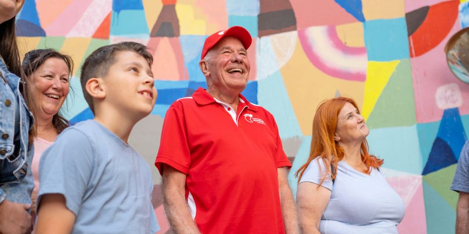 Tourists on a guided walking tour, with city art in the background.