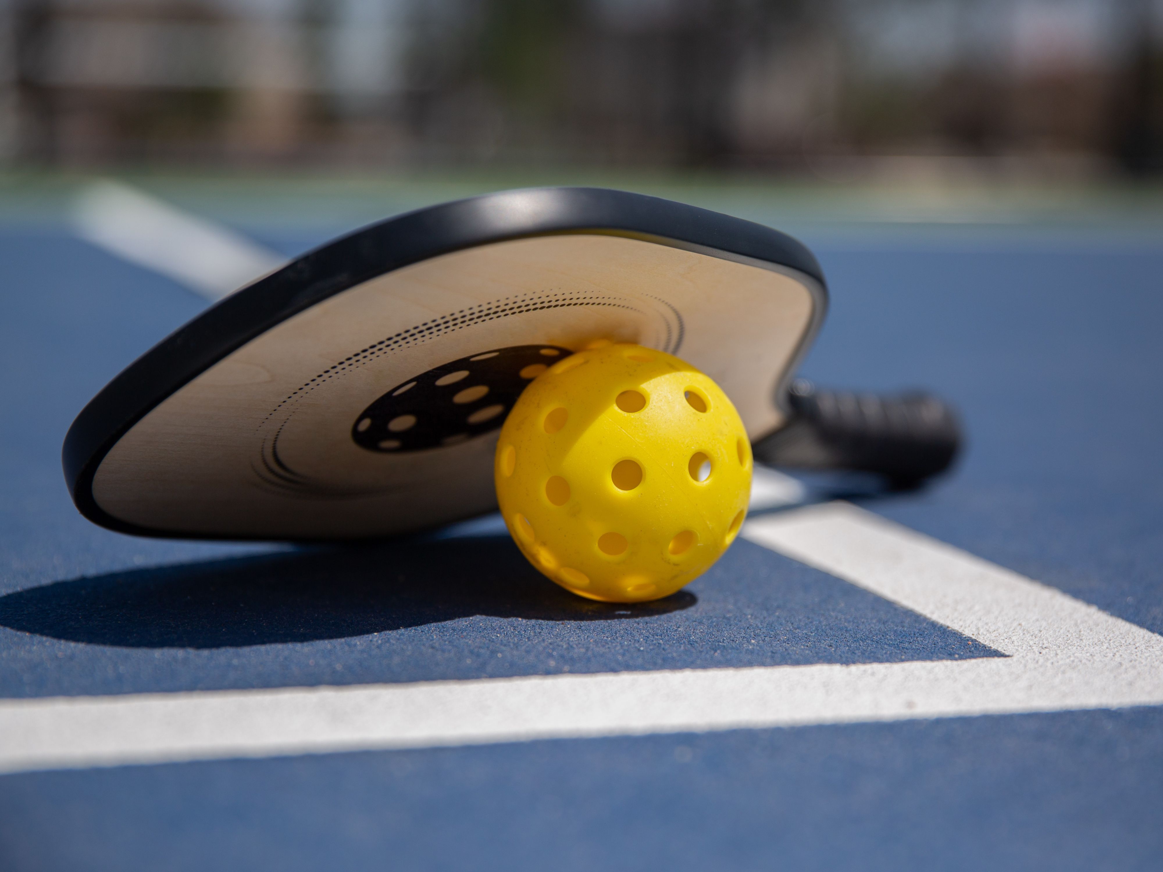 Pickleball racket and ball on a pickleball court