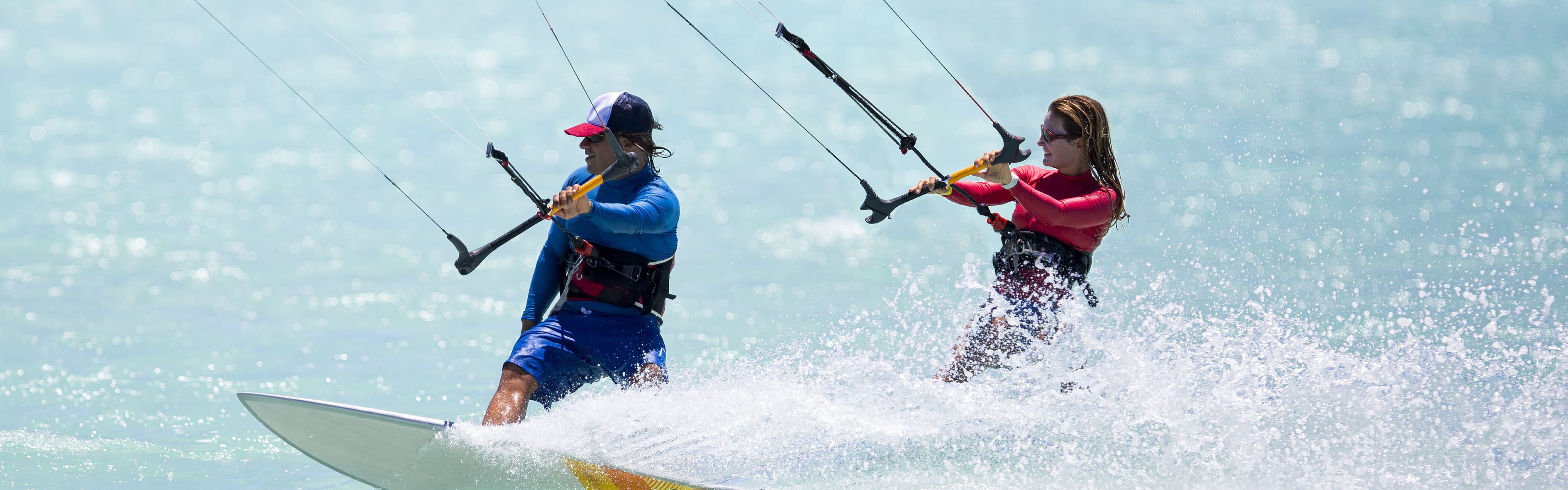 Couple kite surfing in the ocean.