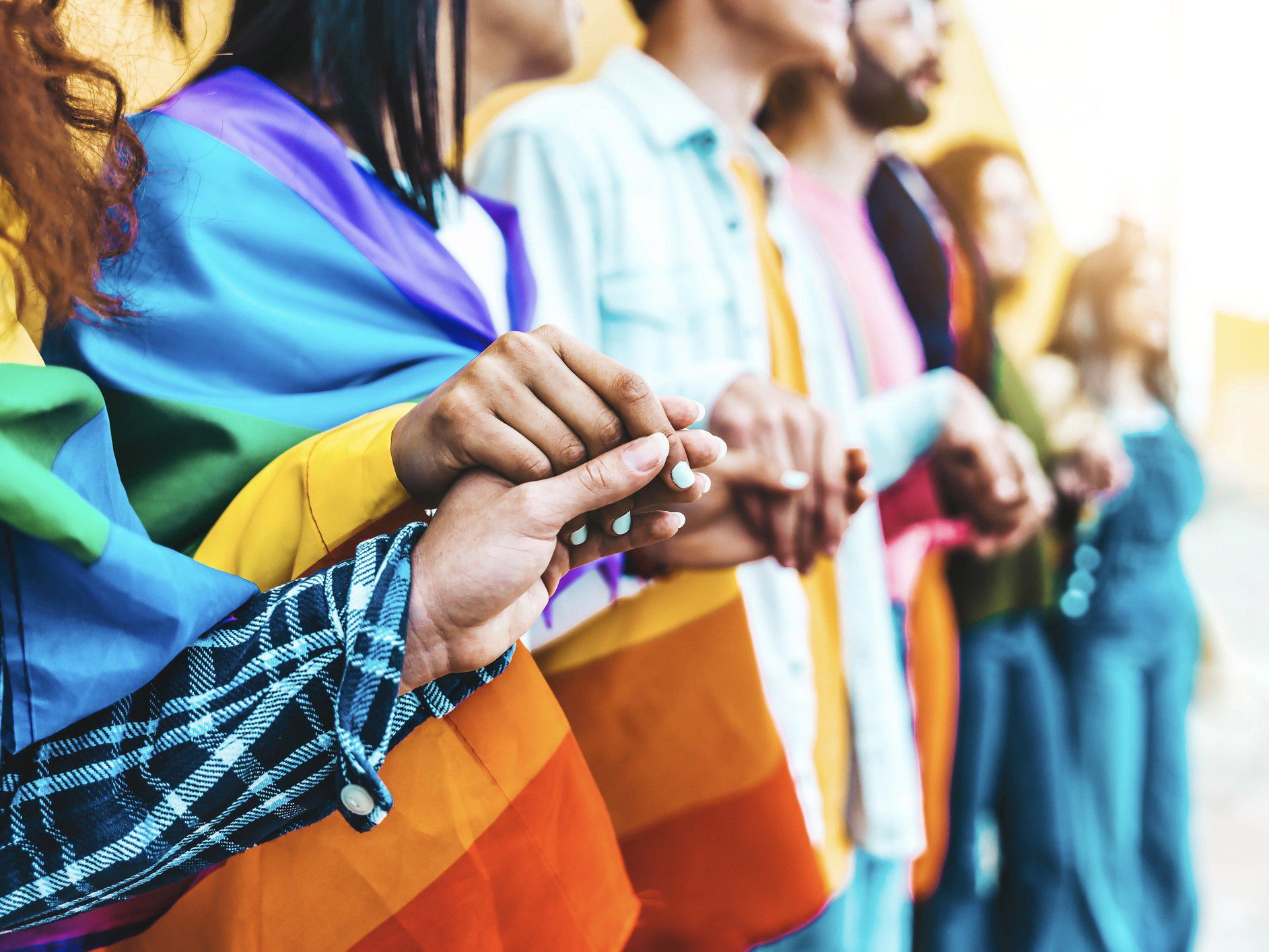 Friends holding hands at Pride