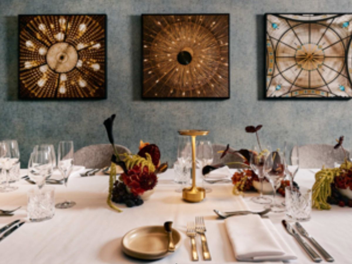 Elegant private dining table with floral arrangements and artwork.
