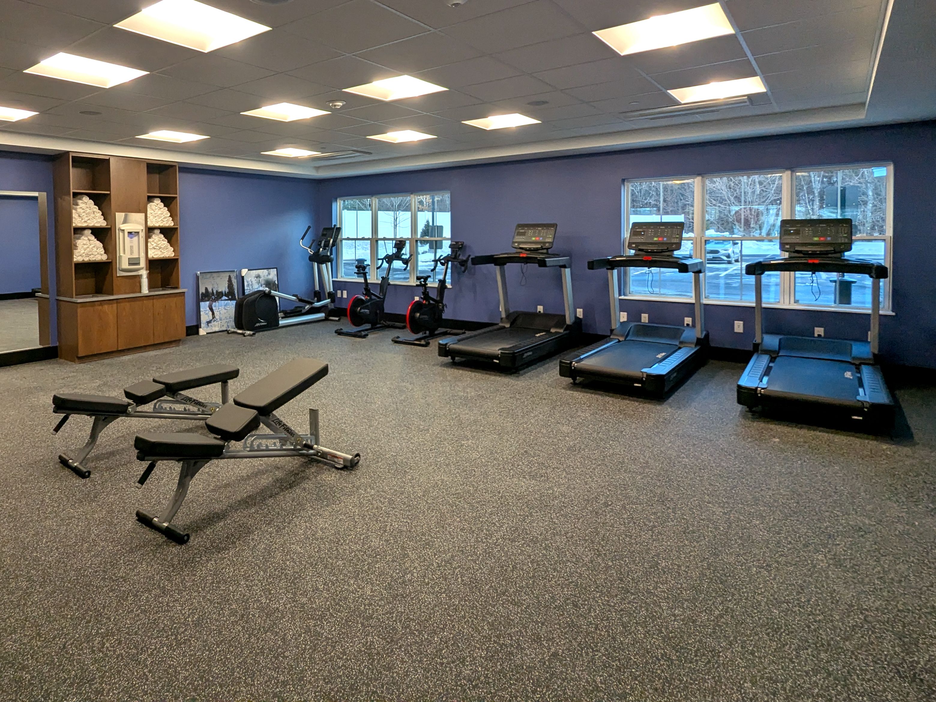 Fitness Center with cardio machines, weights, and towels.