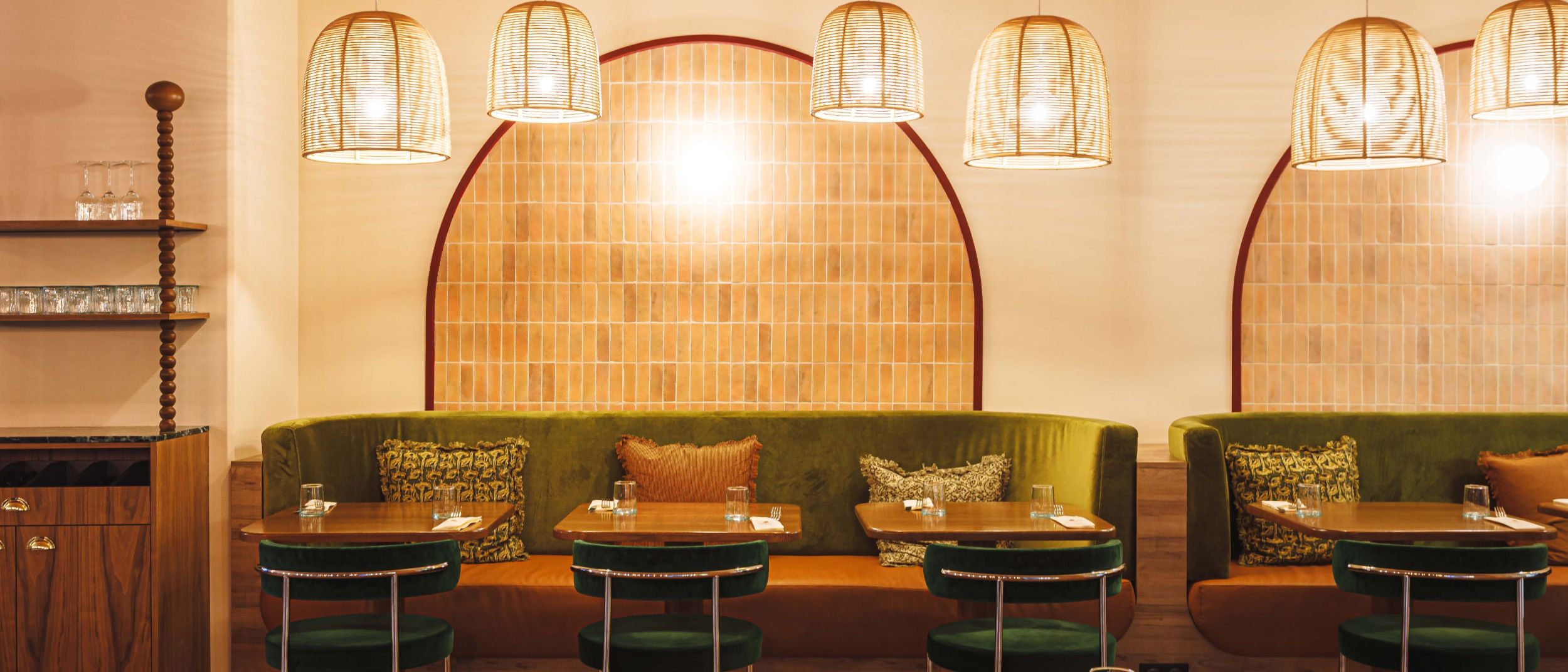 Restaurant interior at Crowne Plaza Lyon - Cite Internationale, with green booth seating and pendant lighting.