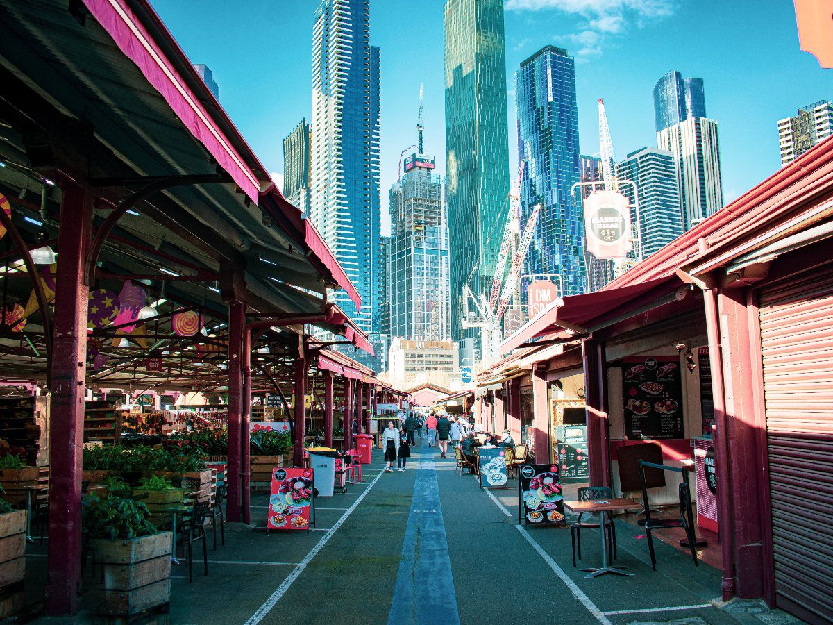 Queen Victoria Market stalls with Melbourne skyline.