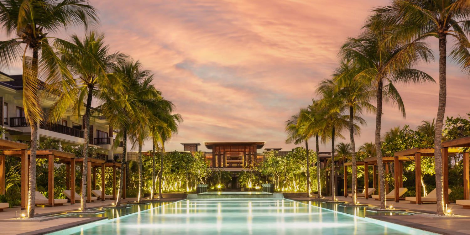 Palm‑lined pool at Regent Bali at sunset