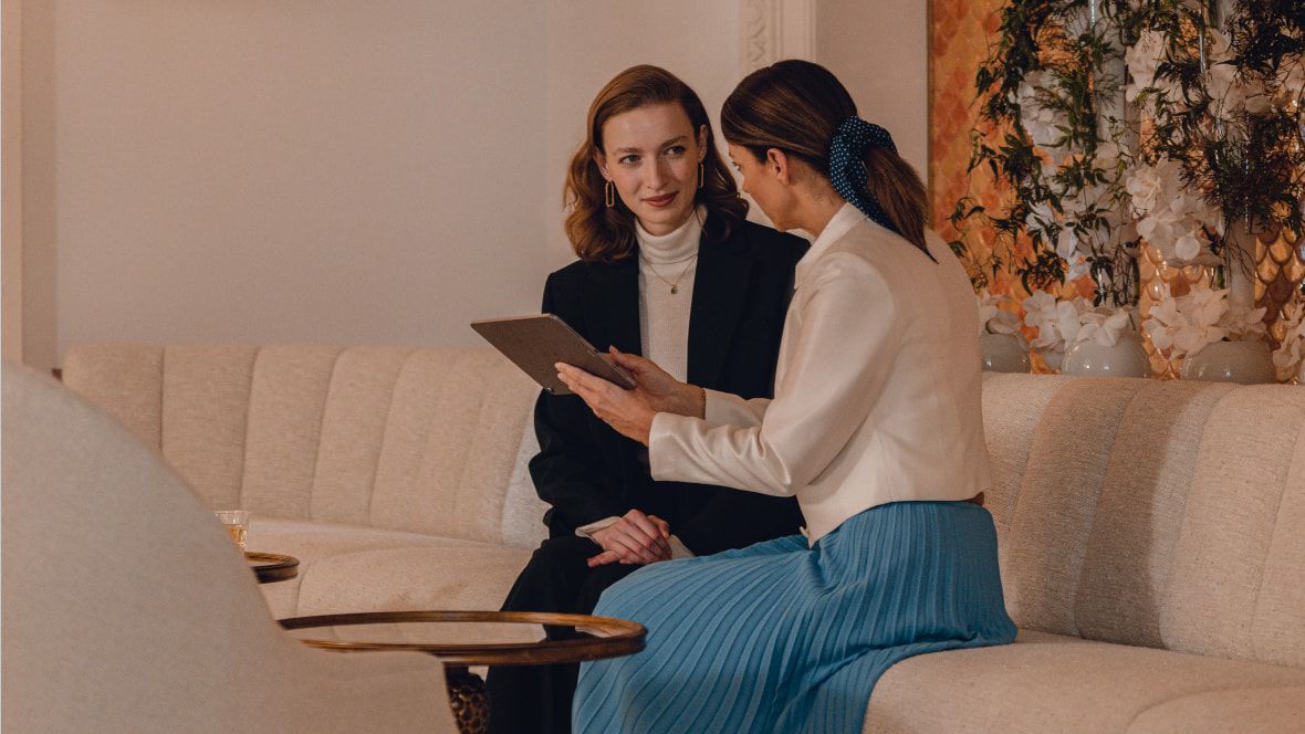 two women sitting on a couch talking