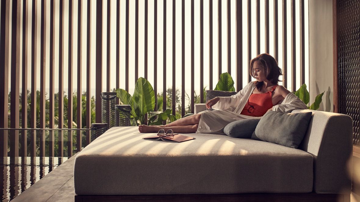 woman relaxing on a lounge next to indoor pool