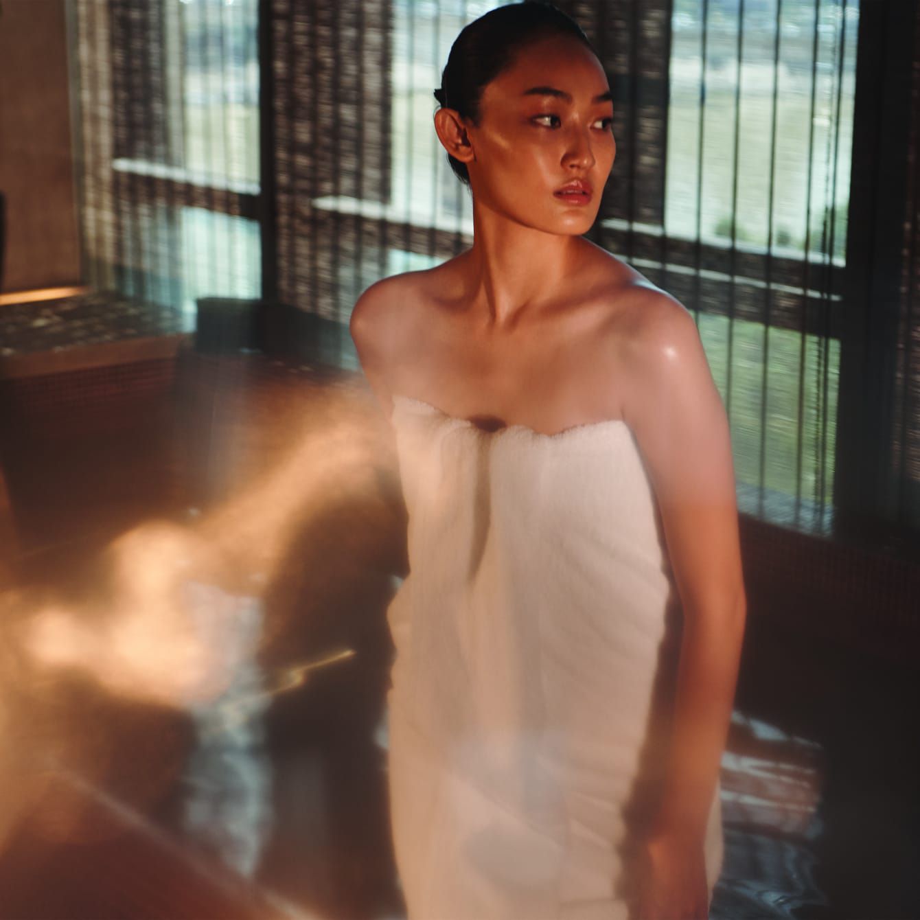 Una mujer en una cámara de vapor relajada ante una vista al aire libre.