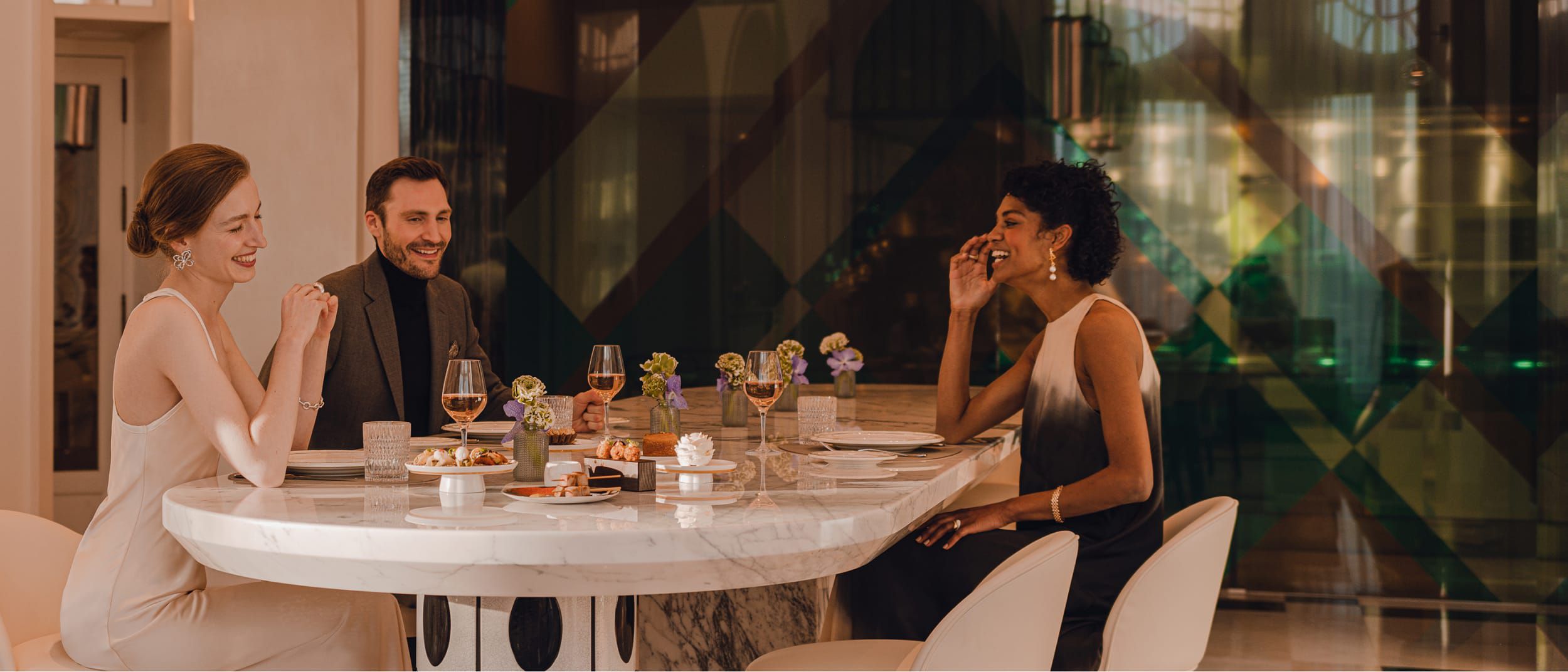 Sekelompok orang menikmati hidangan bersama dengan piring-piring kecil berisi berbagai macam makanan untuk dicicipi.